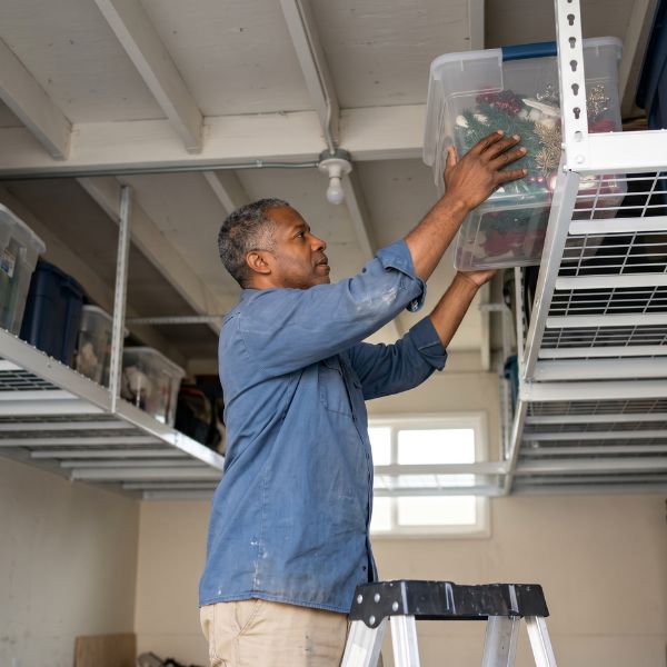 man placing storage bins in garage